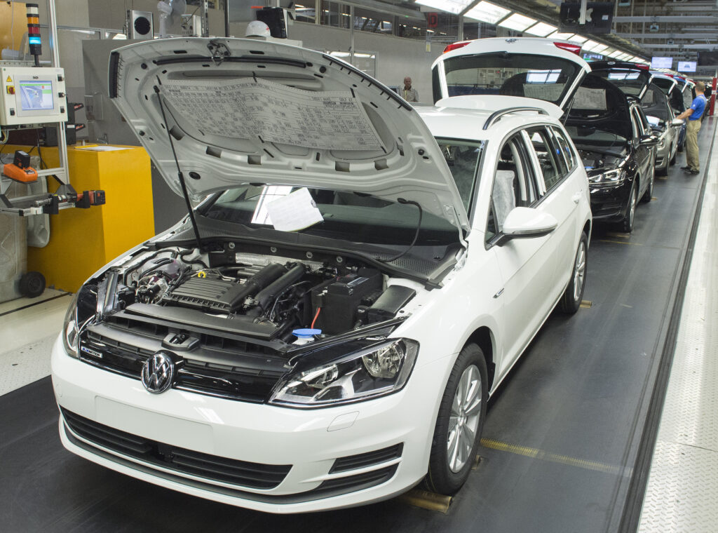 VW-Golf-Modell mit offener Motorhaube auf Band einer Produktionshalle