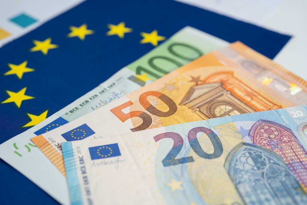 Euro-Banknoten liegen auf EU-Flagge