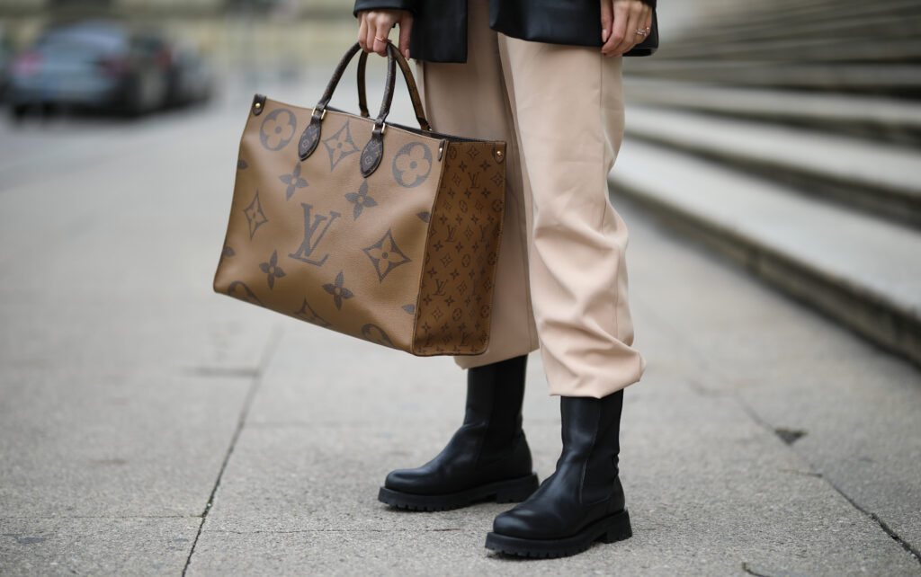 Frau hält Louis Vuitton Tasche in der Hand