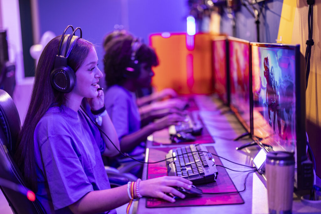 junge Frau mit Headset sitzt vor einem Gaming-Computer