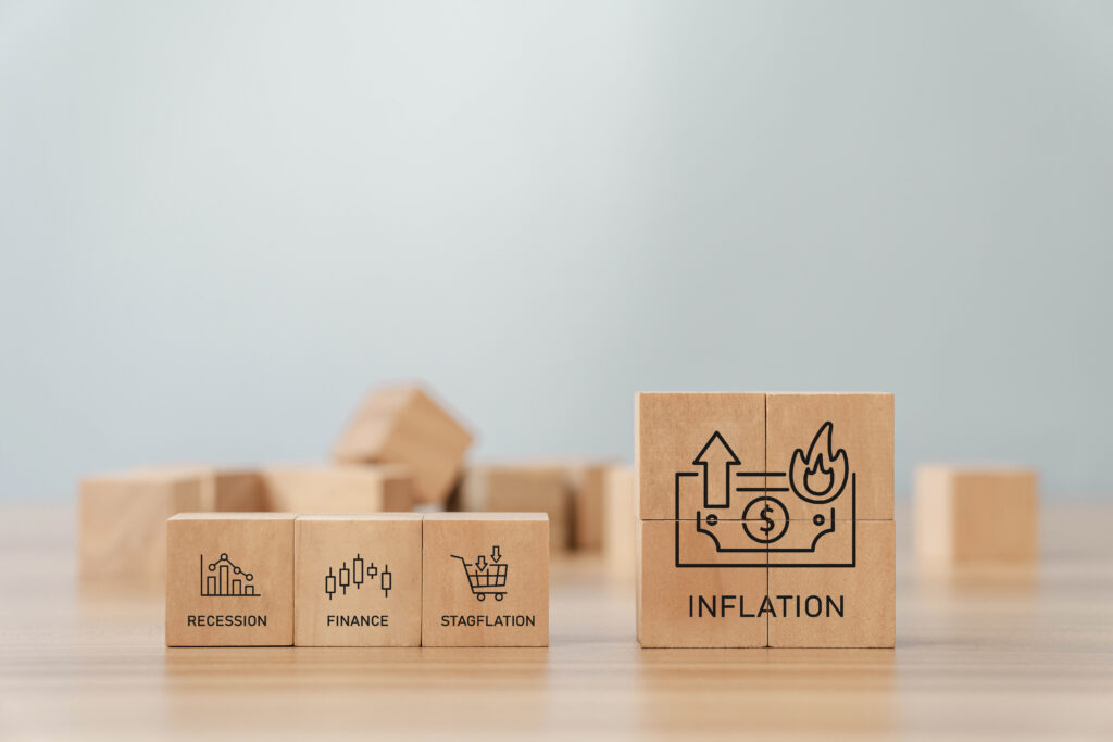 Holzbausteine mit Inflation und drei weiteren Symbolen stehen auf einem Tisch