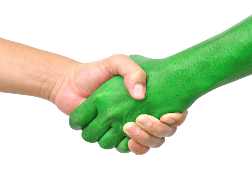 Shake hands einer hellen und einer grünen Hand