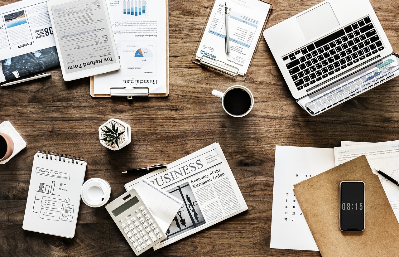 Ein Schreibtisch mit Laptop und Taschenrechner symbolisiert den Einkommensvergleich in Deutschland – Foto: rawpixel / Pixabay