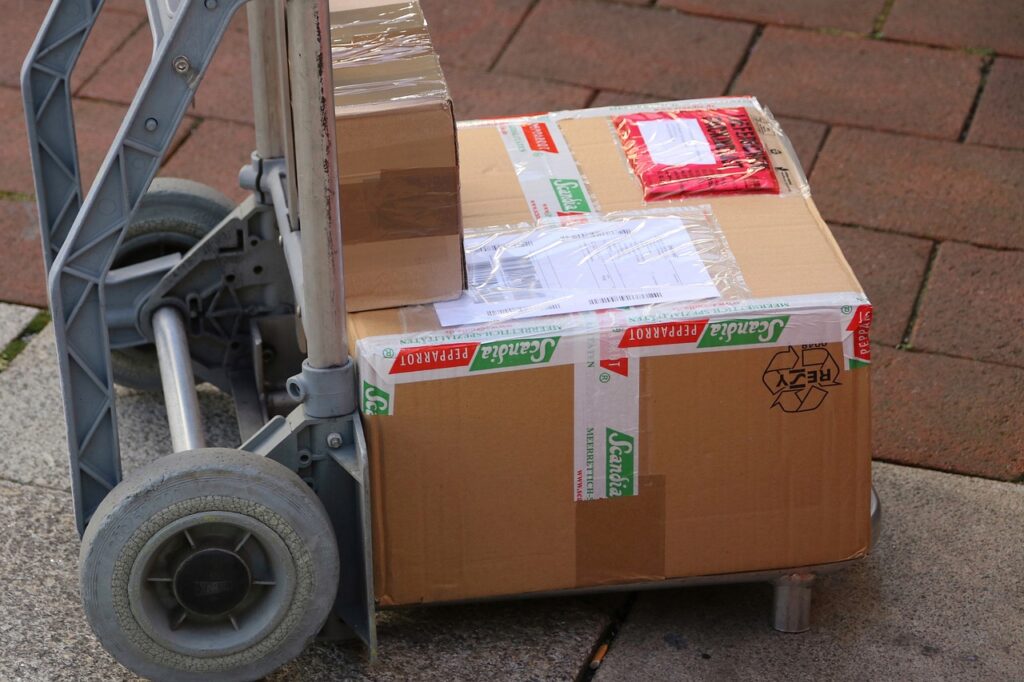 Gestapelte Paketboxen auf einer Laderampe verdeutlichen die hohe Paketmenge in Österreich im Jahr 2025 – Foto: planet_fox / Pixabay