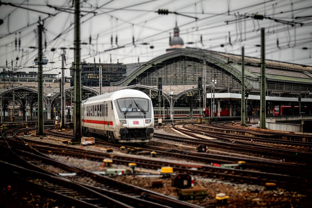 Ein Bahnsteig mit einfahrendem Zug und wartenden Fahrgästen symbolisiert die aktuelle Bahn-KV-Verhandlung bei der ÖBB – Foto: Didgeman / Pixabay