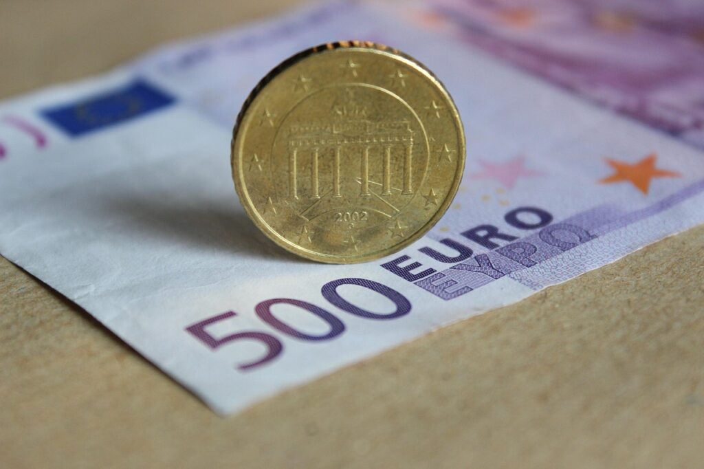 Ein Smartphone mit Banking-App liegt neben Euromünzen auf einem Holztisch, passend zum Thema Chase Zinsen 4 Prozent beim Tagesgeld – Foto: martaposemuckel / Pixabay