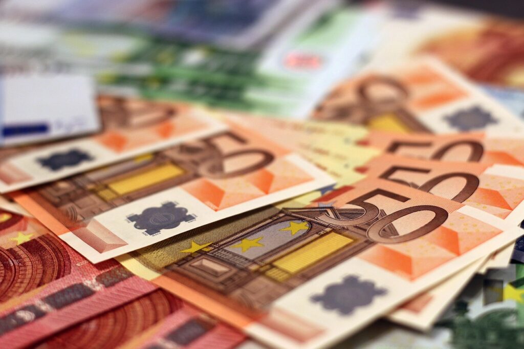 Stapel von Euro-Banknoten und Münzen auf einem Schreibtisch symbolisieren die Milliarden an Steuervergünstigungen in Deutschland – Foto: moerschy / Pixabay
