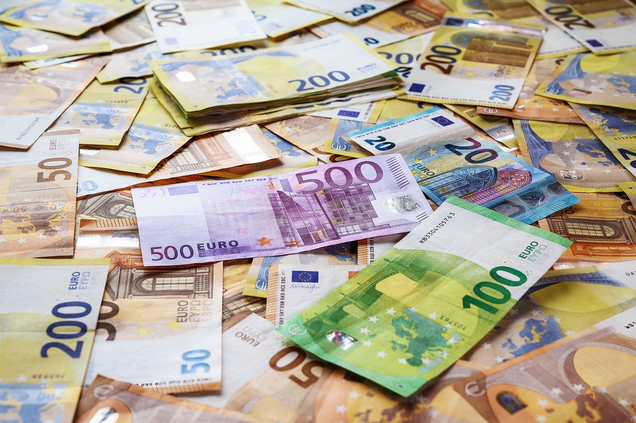 Euro-Geldscheine liegen auf einem Lehrerpult neben Kreide und einem Notenbuch als Sinnbild für die Nachzahlung bei der Besoldung von Lehrkräften – Foto: fotoblend / Pixabay
