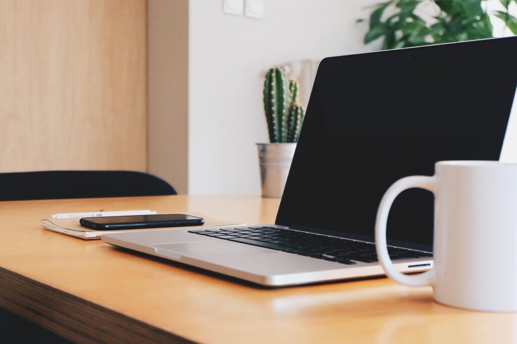 Ein Laptop und ein Smartphone auf einem Schreibtisch stehen sinnbildlich für die wachsende digitale Abhängigkeit in Deutschland – Foto: StockSnap / Pixabay