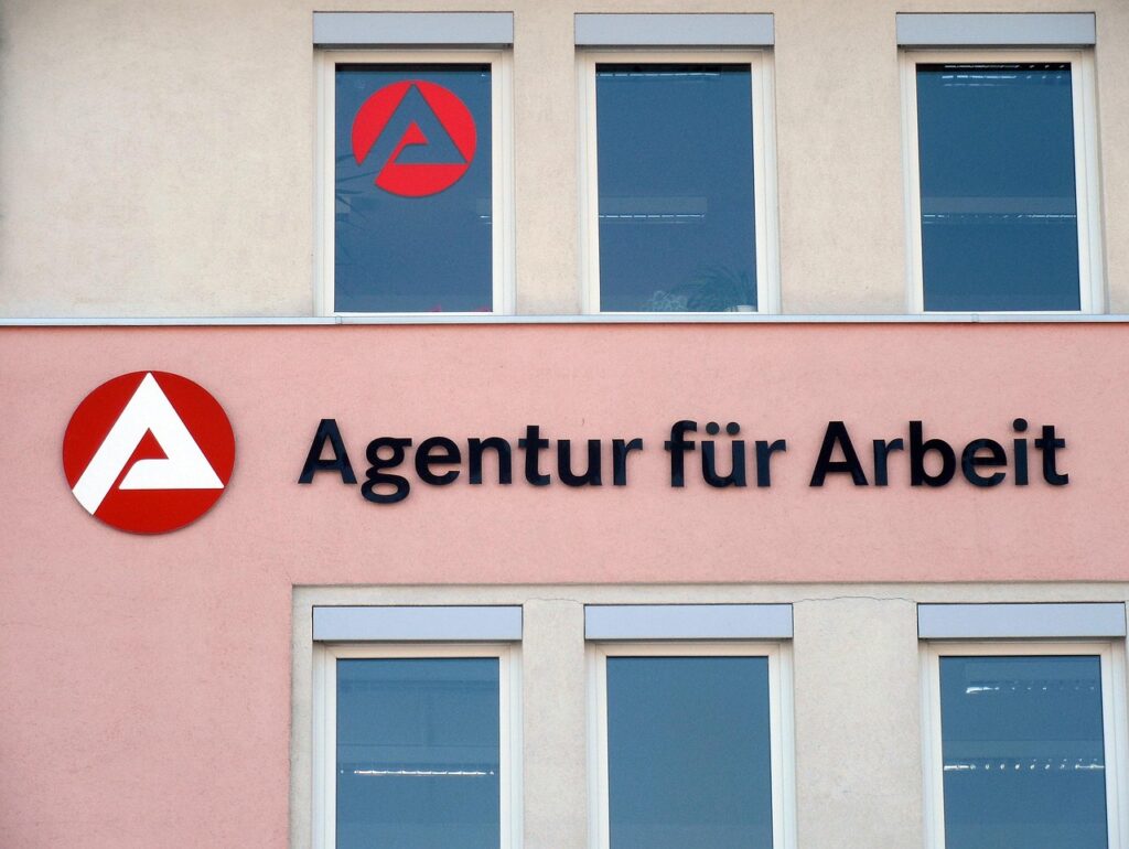 Eingangsbereich einer Arbeitsagentur am Morgen, während das IAB-Arbeitsmarktbarometer wieder über 100 Punkte steigt – Foto: succo / Pixabay
