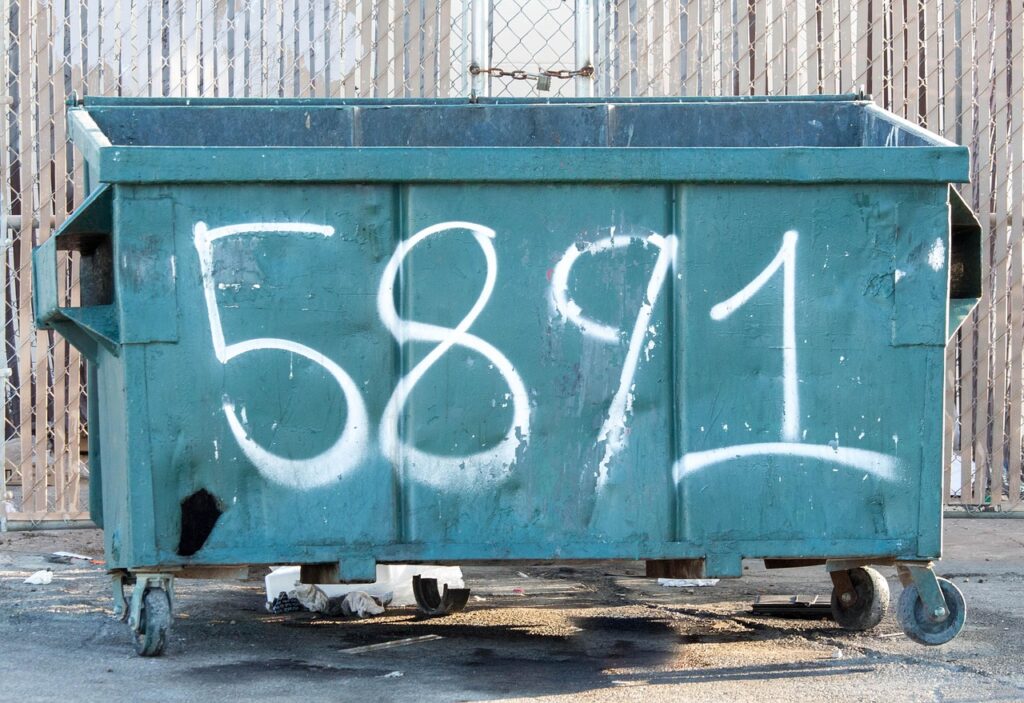 Ein gelber Container für Sperrmüll steht beladen mit altem Mobiliar am Straßenrand, was zeigt wie unterschiedlich hoch die Sperrmüll-Kosten je nach Stadt ausfallen können – Foto: GregReese / Pixabay